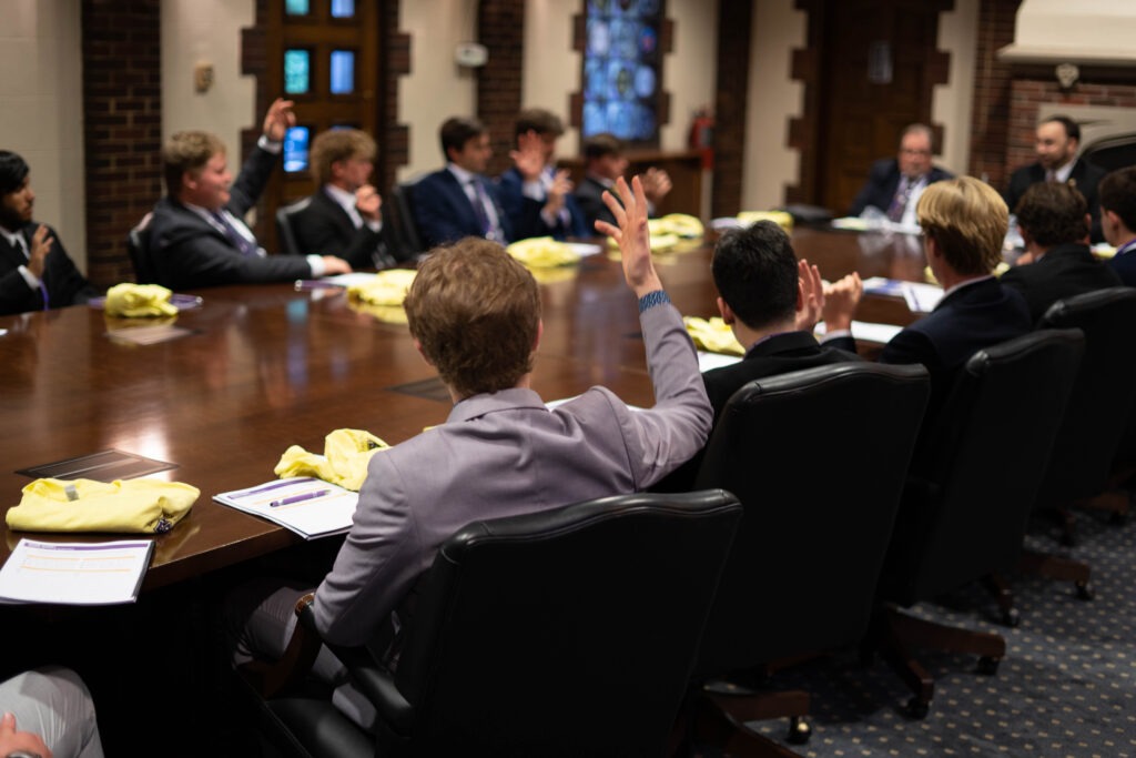 Sigma Alpha Epsilon brothers participating in discussion in the Executive Conference Room